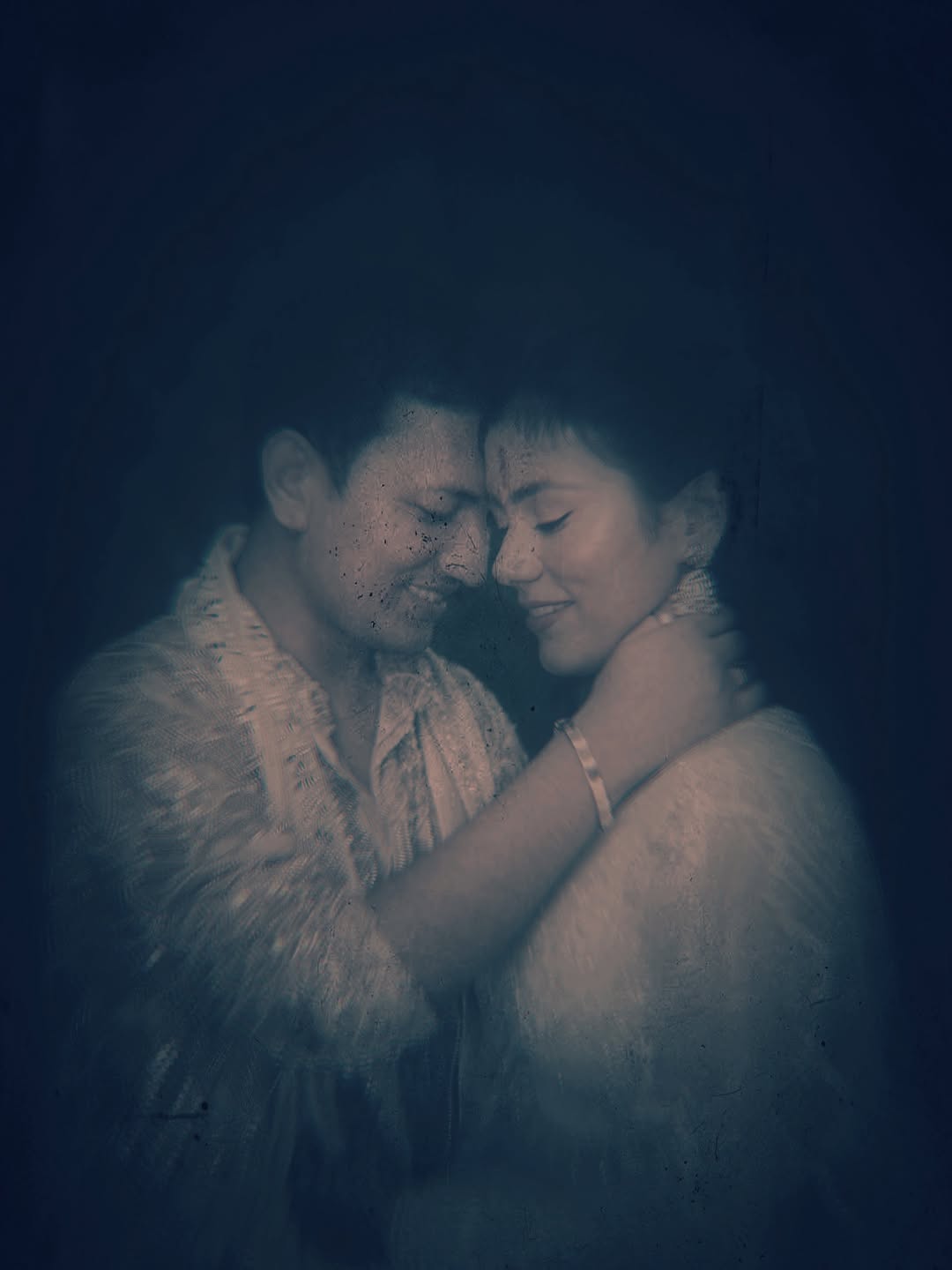 An intimate couple portrait with a cinematic blue treatment